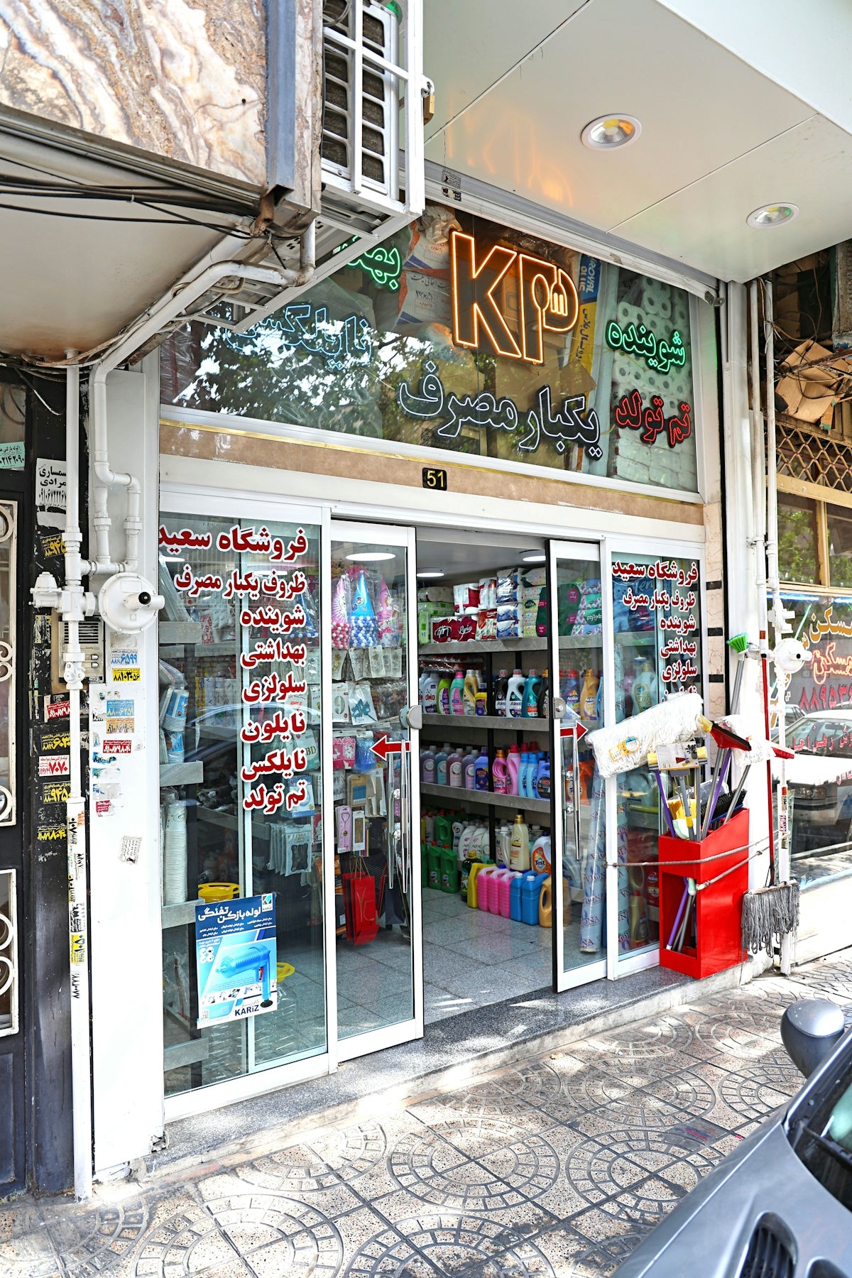 Storefront with sliding glass doors displaying cleaning supplies