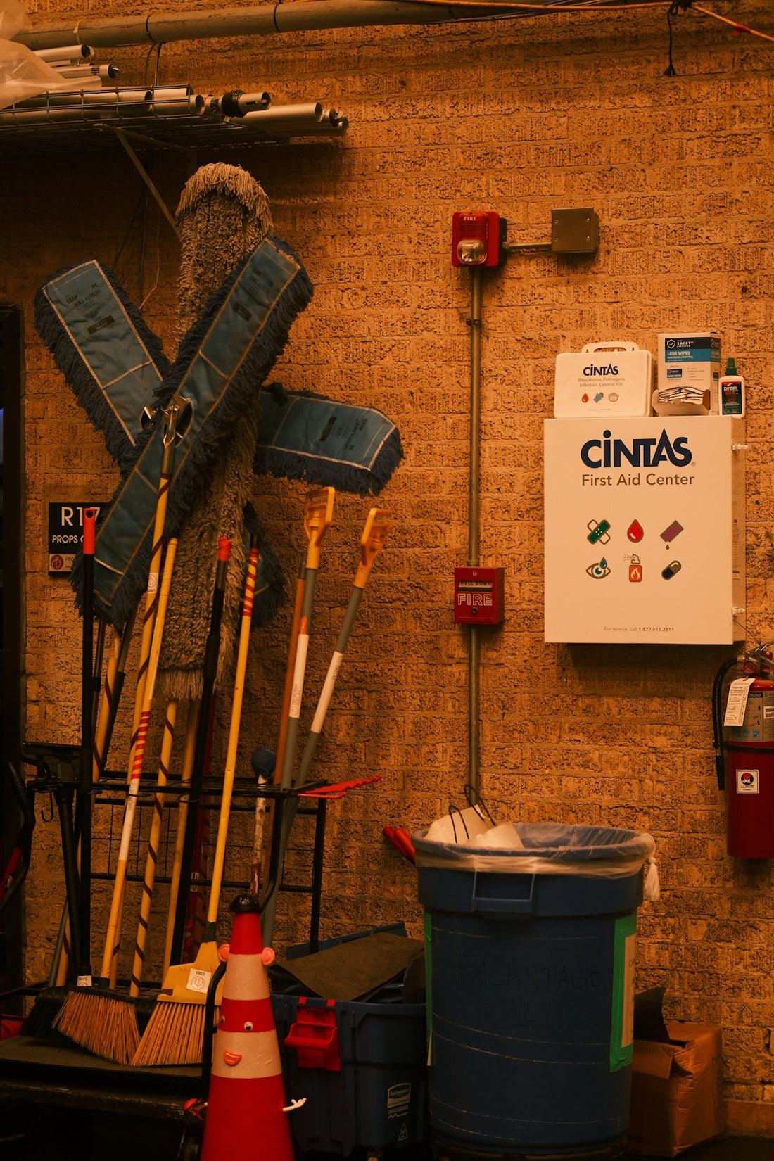 Cleaning supplies and first aid kit on brick wall